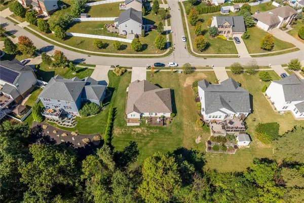 an aerial view of residential houses with outdoor space and parking