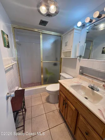 a spacious bathroom with a sink a toilet a mirror and shower