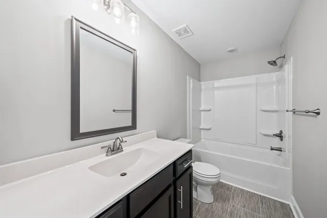 a bathroom with a toilet a sink a mirror and a bathtub