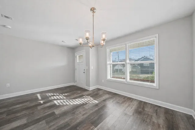 a view of a livingroom with wooden floor and a window