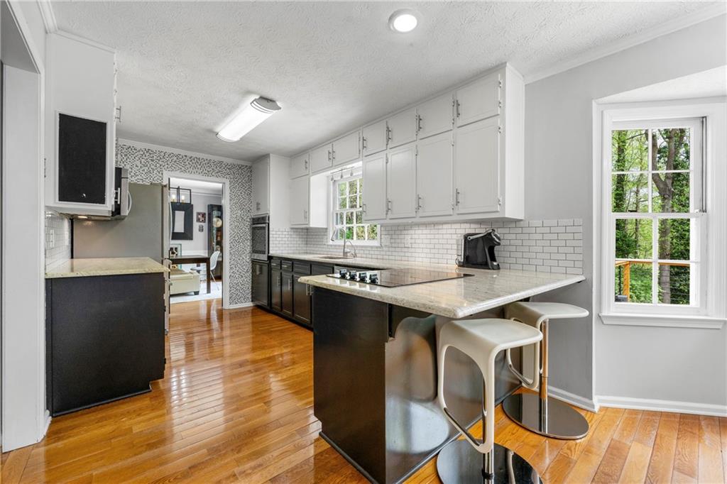 292 Old Rosser Road Stone Mountain, GA 30087 - Photo 16 of 66 a kitchen with stainless steel appliances granite countertop a stove top oven a sink dishwasher and a refrigerator with wooden floor