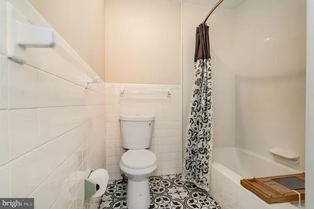 a view of a house with brick walls and a yard with a large tree