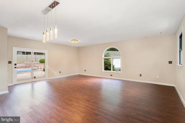 a kitchen with stainless steel appliances granite countertop white cabinets a sink a stove a microwave and wooden floors