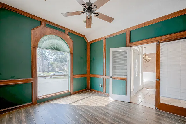 a view of empty room with window and wooden floor