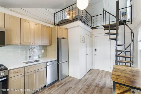 a kitchen with stainless steel appliances granite countertop a refrigerator a stove and a sink with cabinets