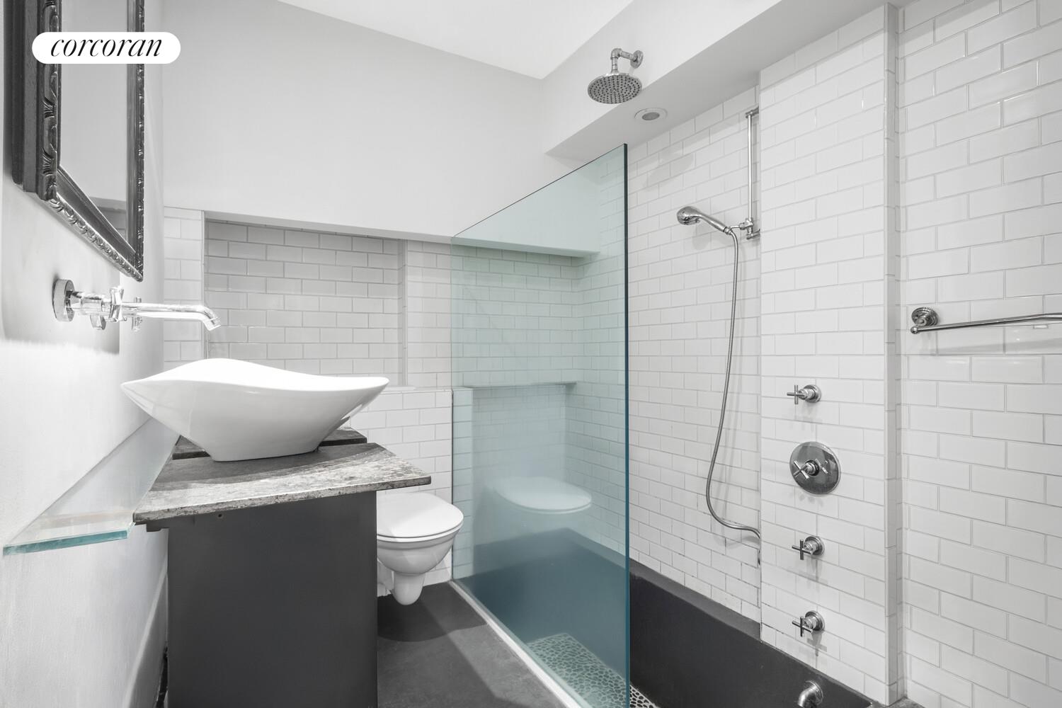 215 East 17th Street, Unit 2 Manhattan, NY 10003 - Photo 5 of 9 a bathroom with a toilet a sink and shower