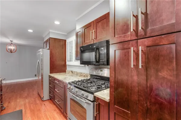 a kitchen with stainless steel appliances granite countertop a refrigerator and a stove top oven