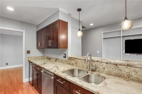a kitchen with granite countertop a sink and a refrigerator