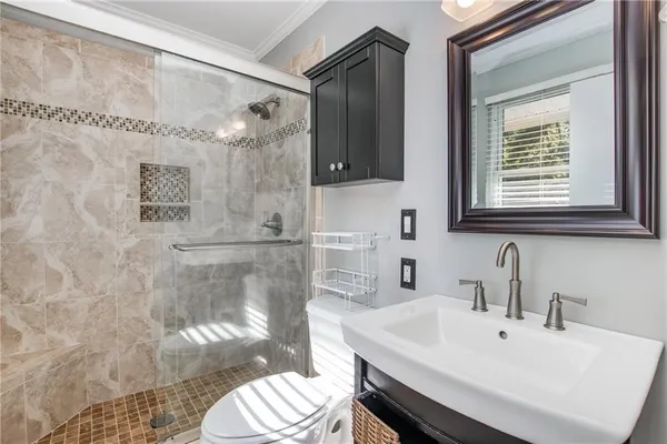 a bathroom with a sink a toilet and shower