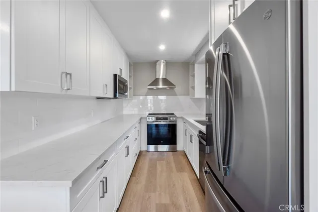 a kitchen with stainless steel appliances granite countertop a refrigerator and a stove