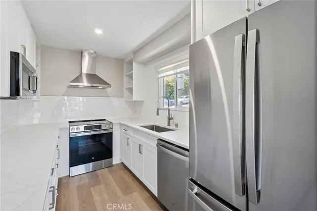 a kitchen with stainless steel appliances granite countertop a stove a refrigerator and a sink