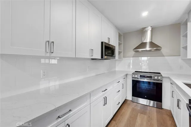 a kitchen with stainless steel appliances a sink stove and cabinets