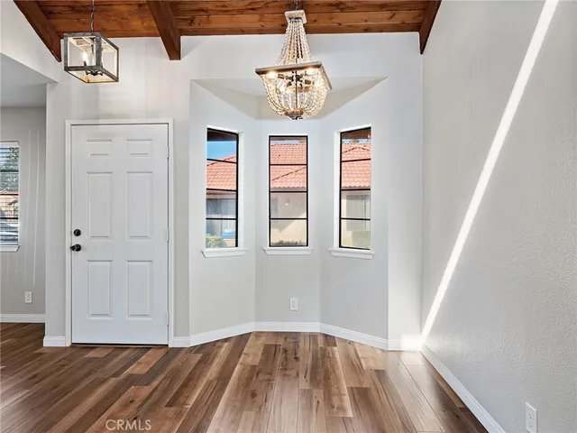 a view of hallway with wooden floor and chandelier