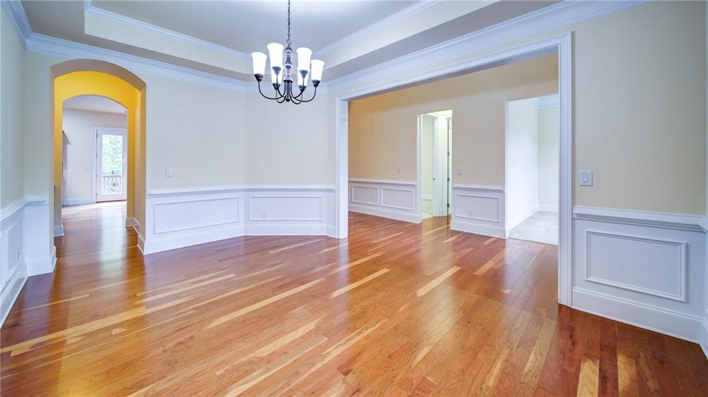 2220 Stirling Bridge Road Cumming, GA 30041 - Photo 12 of 82 a view of empty room with wooden floor and chandelier