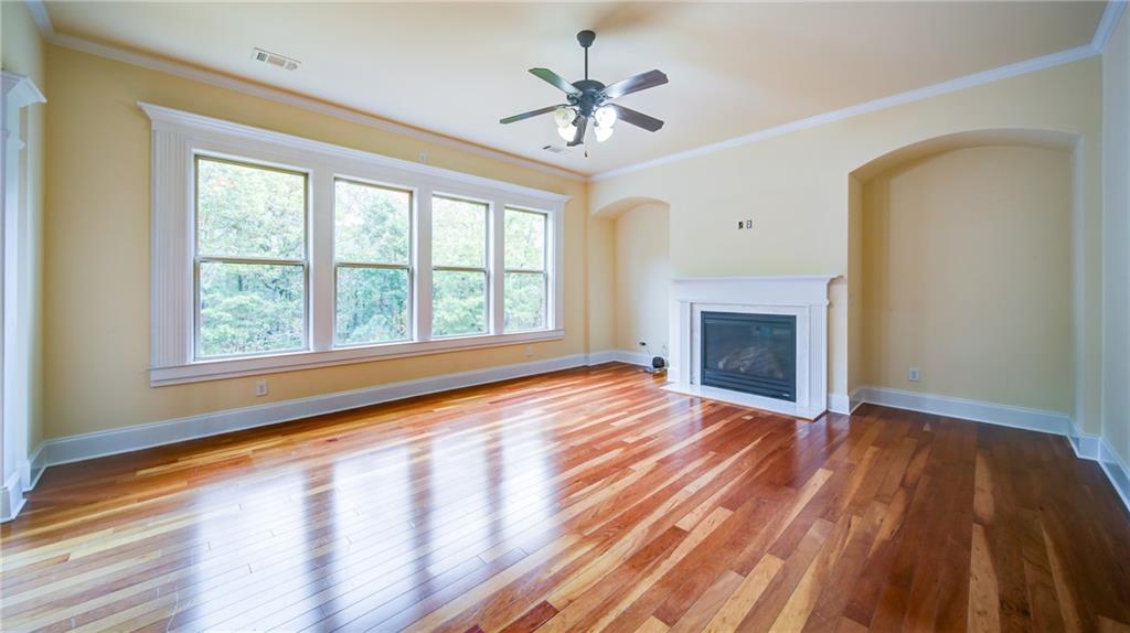 2220 Stirling Bridge Road Cumming, GA 30041 - Photo 15 of 82 wooden floor fireplace and windows in an empty room