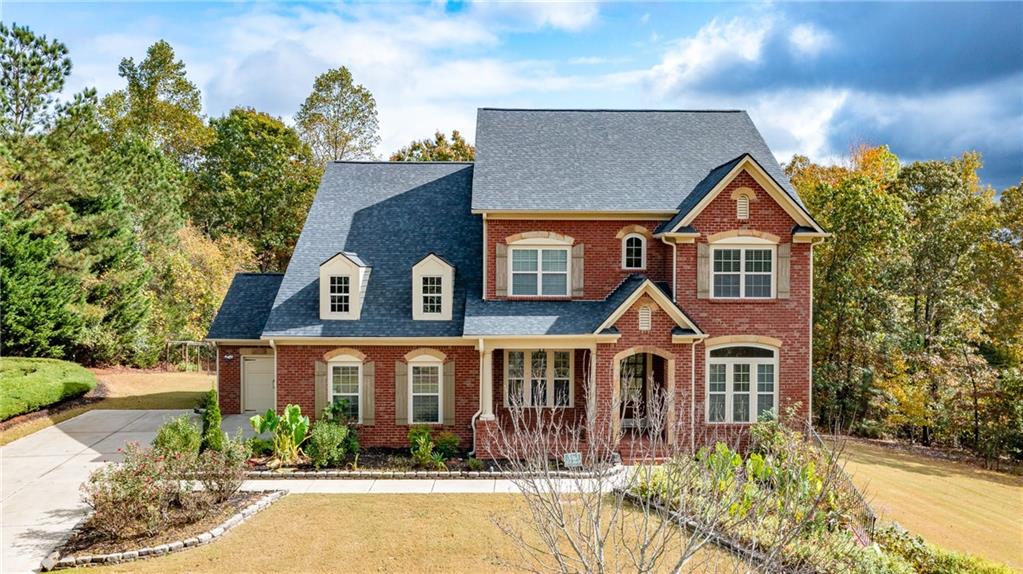 2220 Stirling Bridge Road Cumming, GA 30041 - Photo 2 of 82 a front view of a house with lots of trees and plants