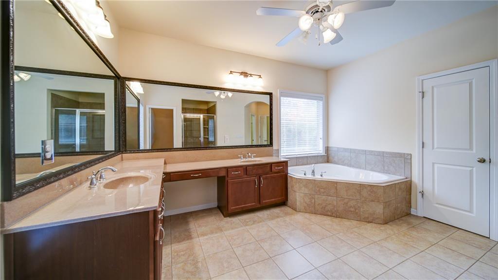 2220 Stirling Bridge Road Cumming, GA 30041 - Photo 43 of 82 a spacious bathroom with a tub sink and mirror