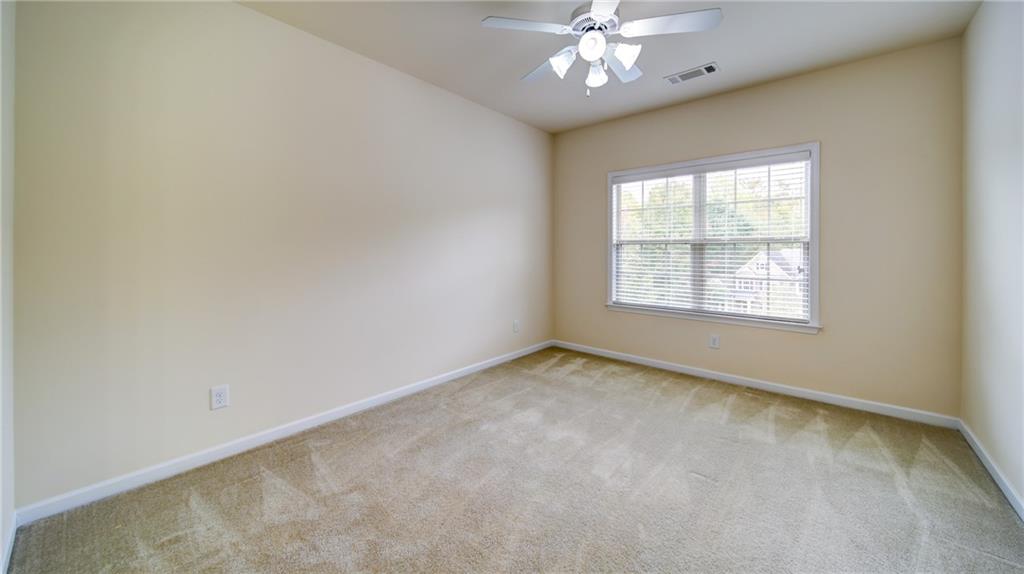 2220 Stirling Bridge Road Cumming, GA 30041 - Photo 52 of 82 an empty room with a chandelier fan and windows
