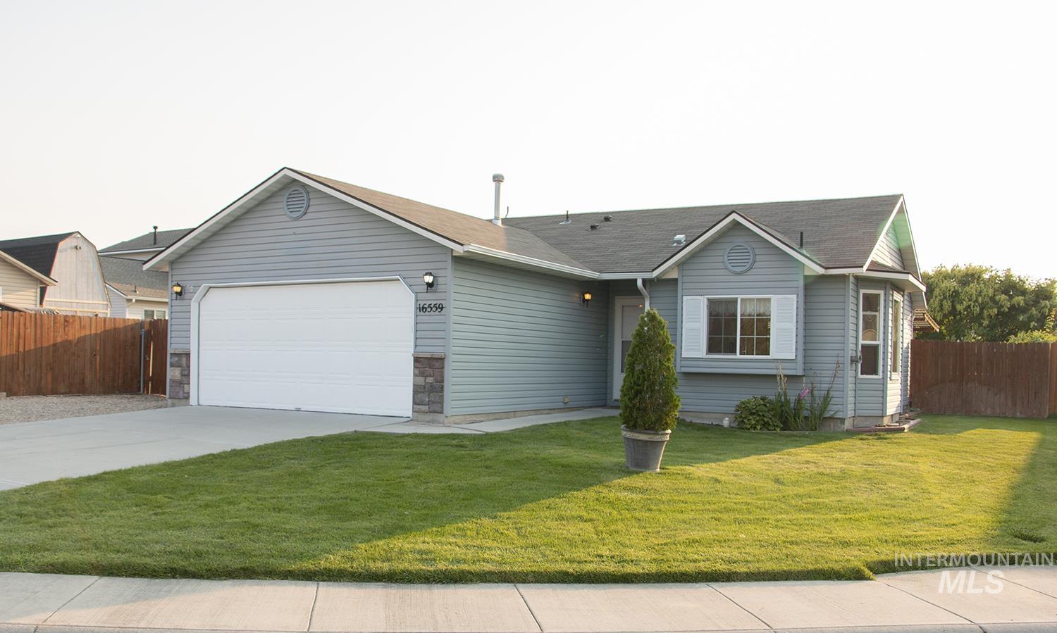 16559 Bayou Way Caldwell, ID 83607 - Photo 2 of 20 Single-level residence featuring gray siding, a two-car garage, and a concrete driveway