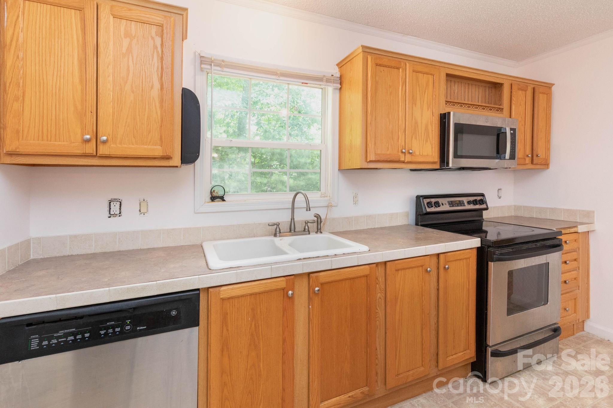 16 Rusty Clay Ridge Fairview, NC 28730 - Photo 15 of 19 a kitchen with stainless steel appliances granite countertop a sink a stove and a microwave