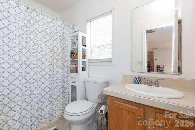 a bathroom with a granite countertop toilet and a sink