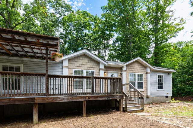 a view of a house with a deck and a yard