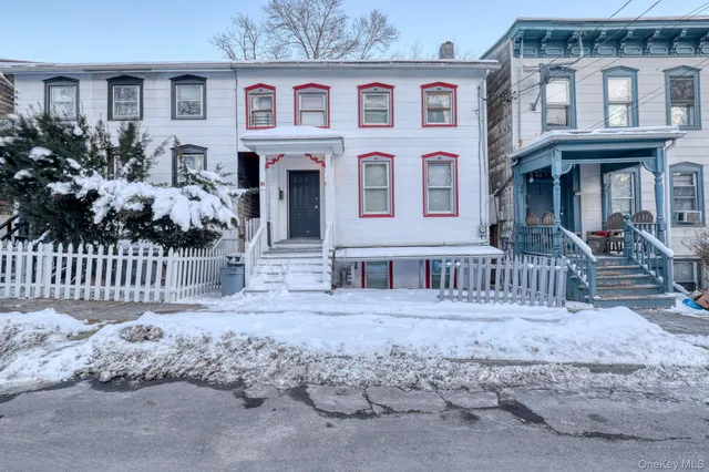 a view of a brick house with large windows and a small yard