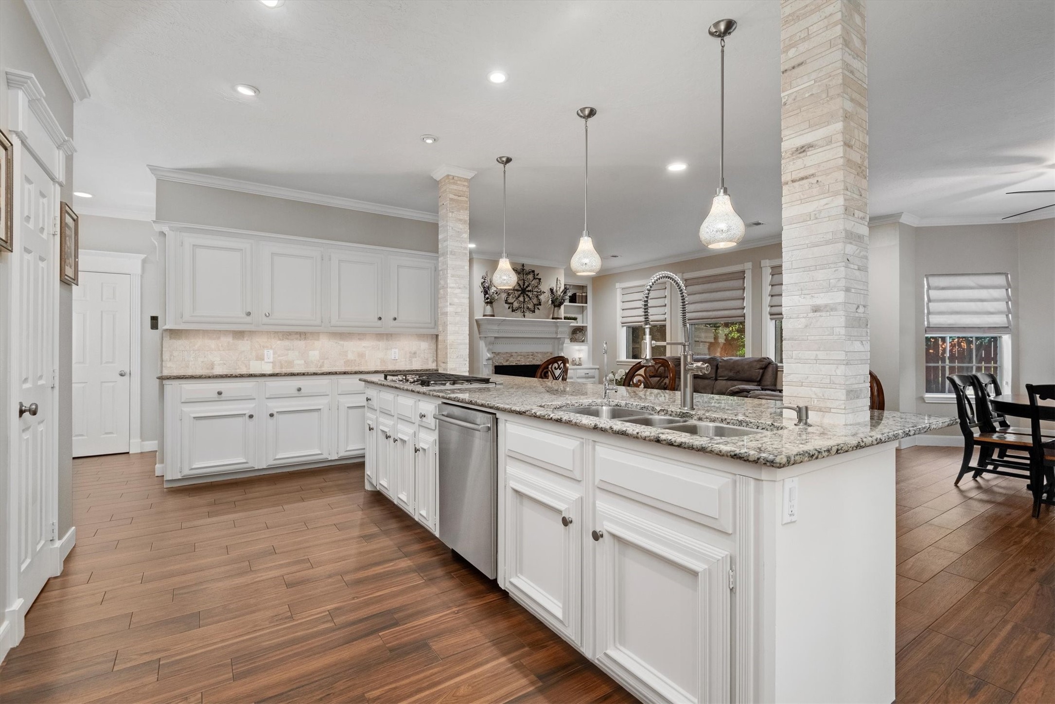 16022 Stewarts Grove Drive Spring, TX 77379 - Photo 18 of 45 a kitchen with stainless steel appliances kitchen island granite countertop a stove a sink and white cabinets with wooden floor