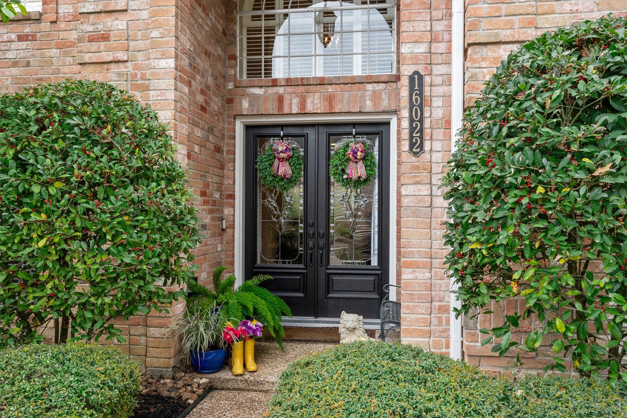 16022 Stewarts Grove Drive Spring, TX 77379 - Photo 6 of 45 HOME EXTERIOR: The welcoming double front door greets visitors, accompanied by lush landscaping that invites guests to step inside this beautiful custom home.