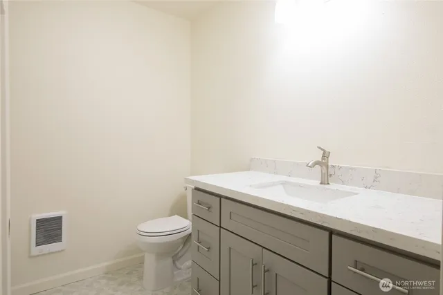 a bathroom with a toilet a sink and mirror