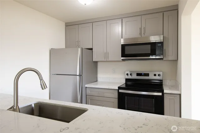 a kitchen with a refrigerator and a stove top oven