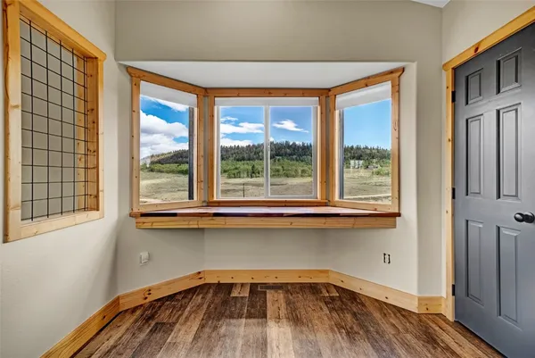a view of a kitchen with wooden floor and a window