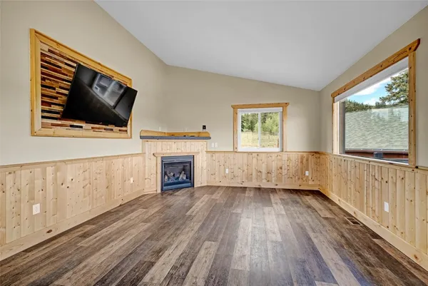 a view of a livingroom with wooden floor fireplace and windows