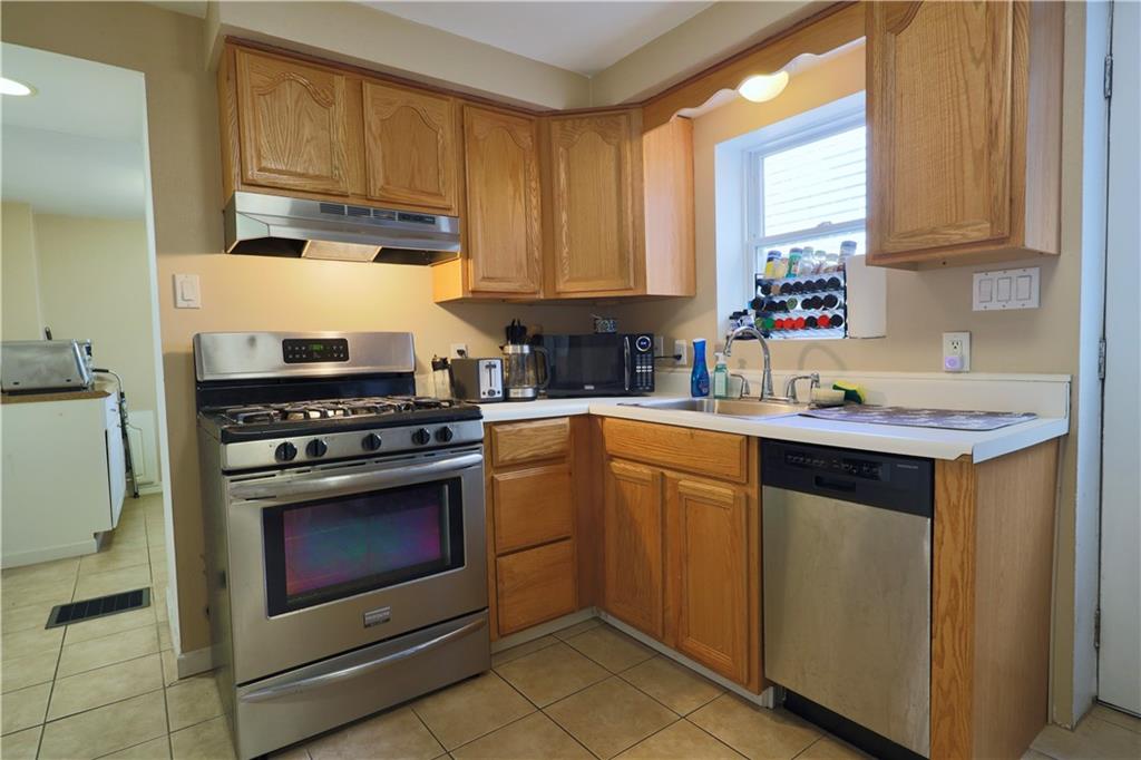 1923 Wharton Street Pittsburgh, PA 15203 - Photo 15 of 34 a kitchen with stainless steel appliances granite countertop a sink stove and cabinets