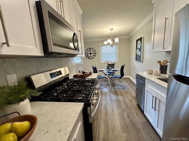 111 College Road, Unit 15C Selden, NY 11784 - Photo 2 of 10 a kitchen with granite countertop a stove a sink dishwasher and cabinets with wooden floor