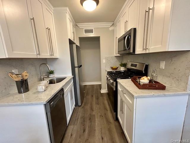 111 College Road, Unit 15C Selden, NY 11784 - Photo 3 of 10 a kitchen with stainless steel appliances granite countertop a sink stove and cabinets