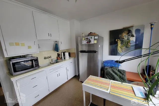 a kitchen with stainless steel appliances white cabinets and wooden floor