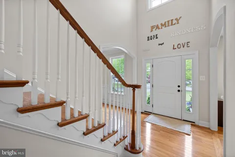 a view of staircase with lots of frames on wall and a window