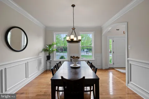 a dining room with furniture a window and wooden floor