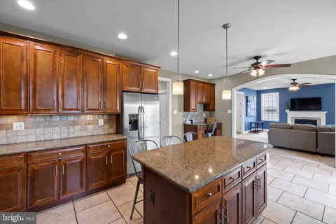 a kitchen with stainless steel appliances granite countertop a sink a stove and a refrigerator