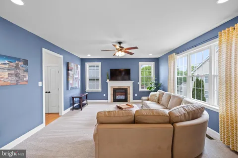 a living room with furniture a fireplace and a large window