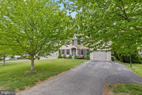 a front view of a house with yard and green space