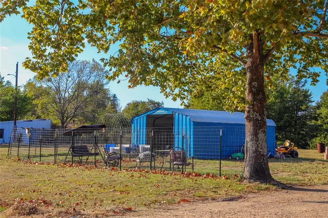 a backyard of a house with barbeque oven and outdoor seating