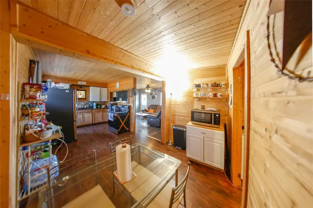 a view of a dining room with furniture one side kitchen view and a wooden floor