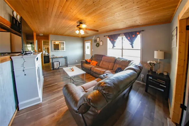 a living room with furniture a flat screen tv and wooden floor