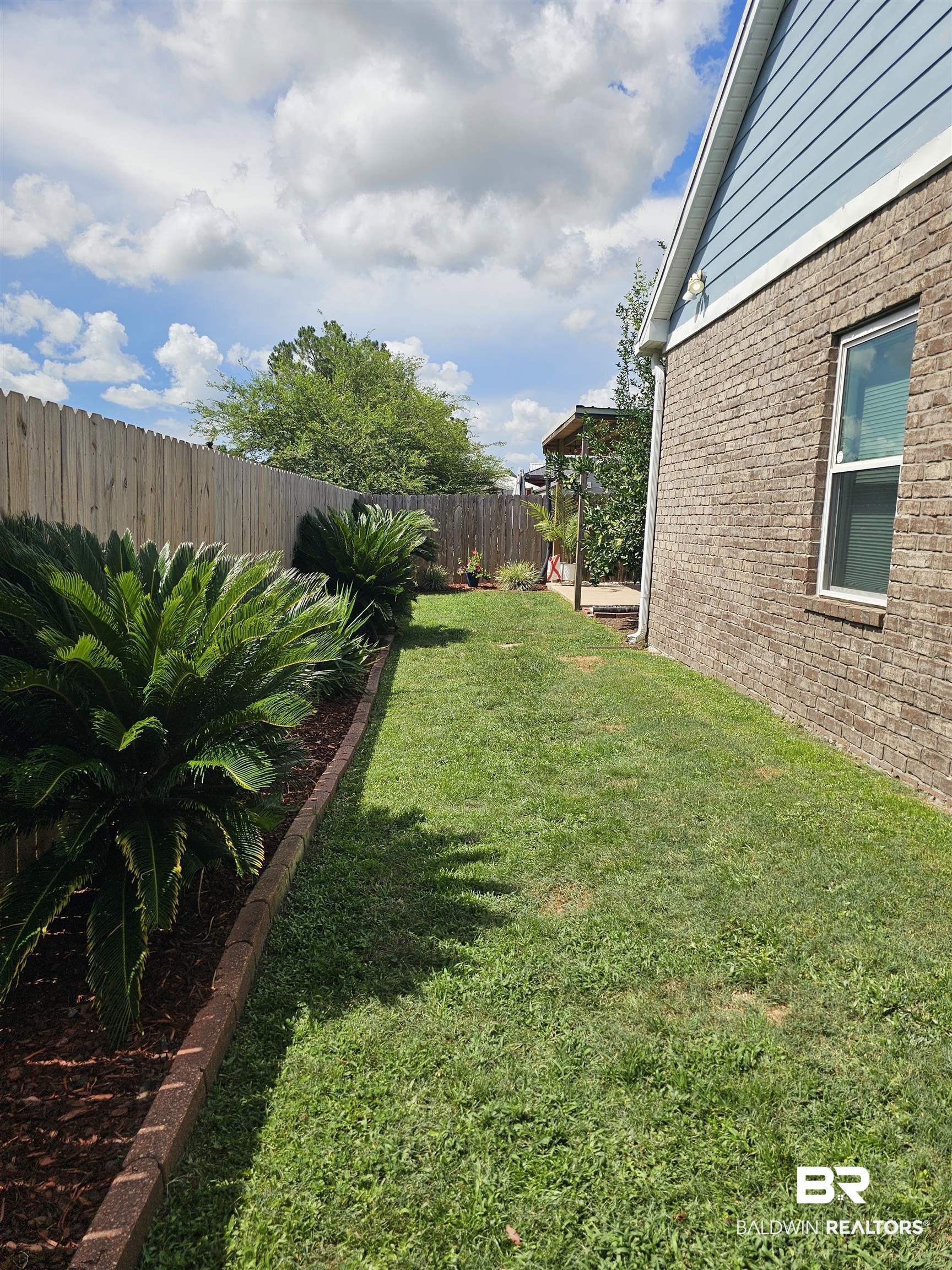 1181 Sloane Cove Foley, AL 36535 - Photo 7 of 10 Side yard with a wood privacy fence and a brick house exterior