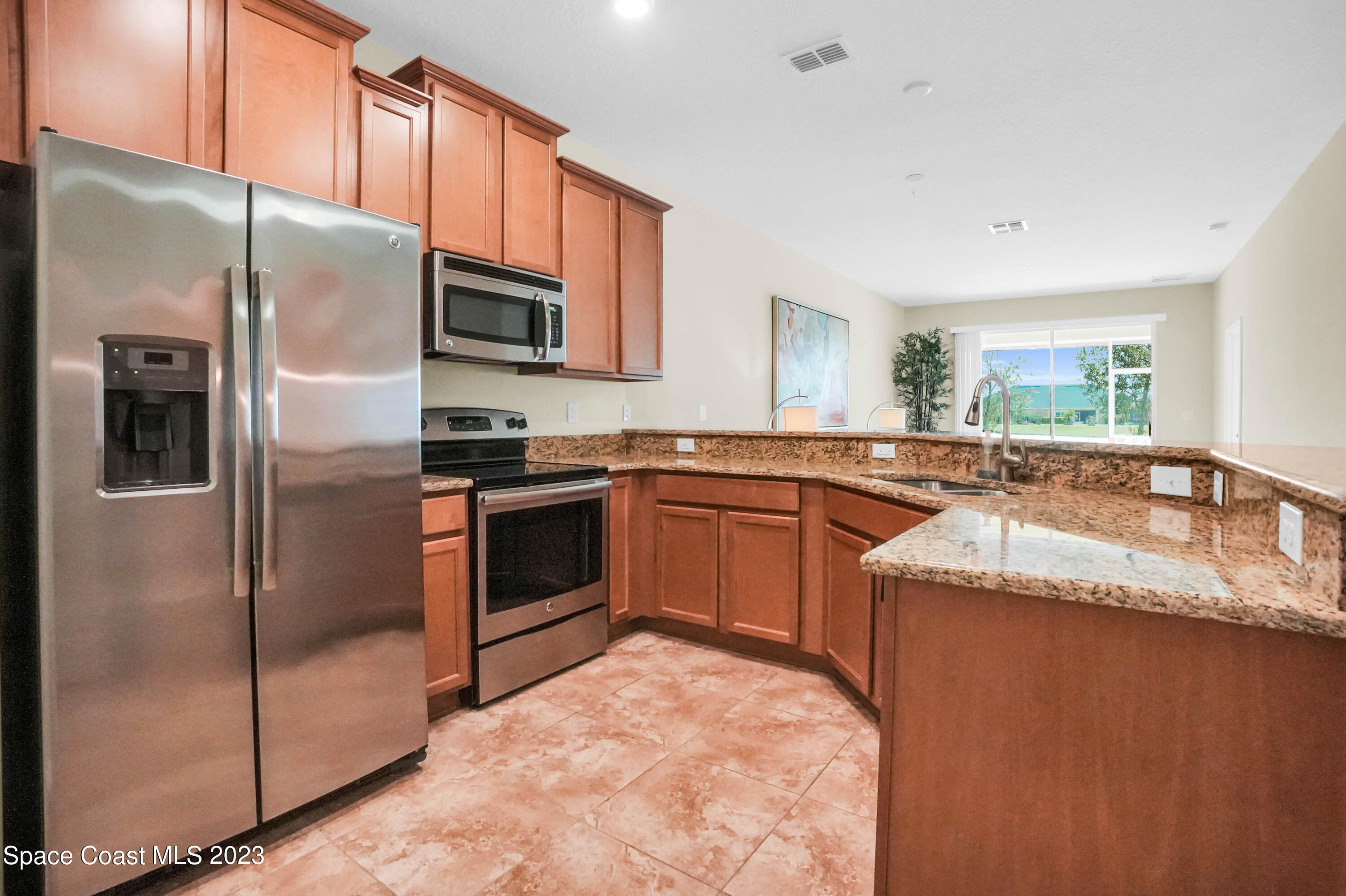 5928 Van Ness Drive Melbourne, FL 32940 - Photo 12 of 35 a kitchen with stainless steel appliances granite countertop a refrigerator and a sink