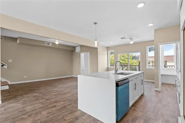 a view of a kitchen with a sink and dishwasher with wooden floor