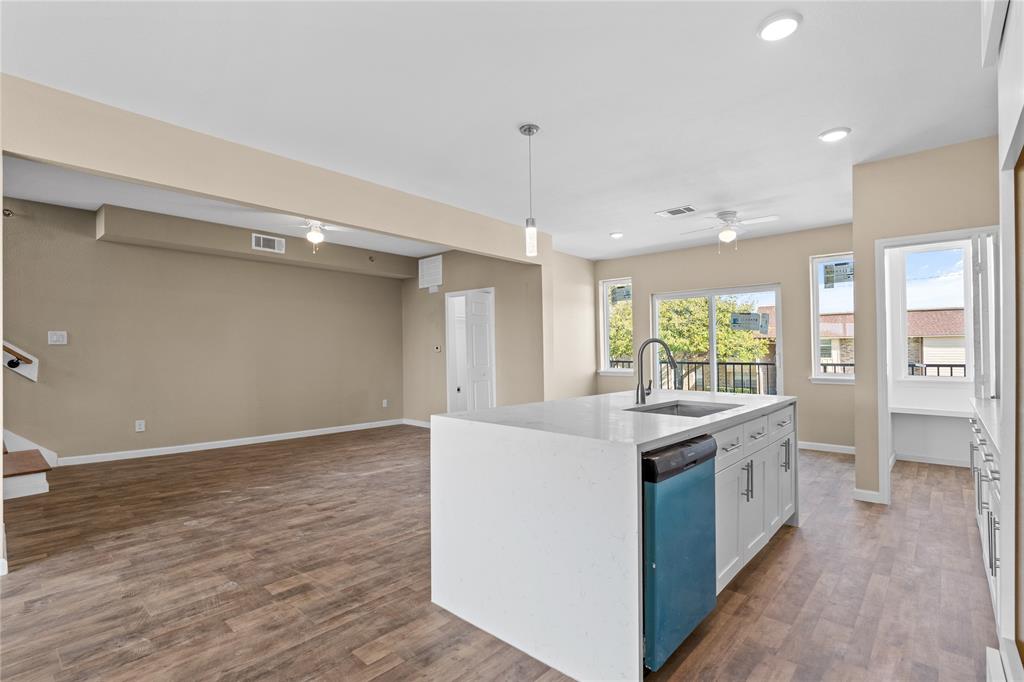 3607 Portland Street Irving, TX 75062 - Photo 14 of 25 a view of a kitchen with a sink and dishwasher with wooden floor