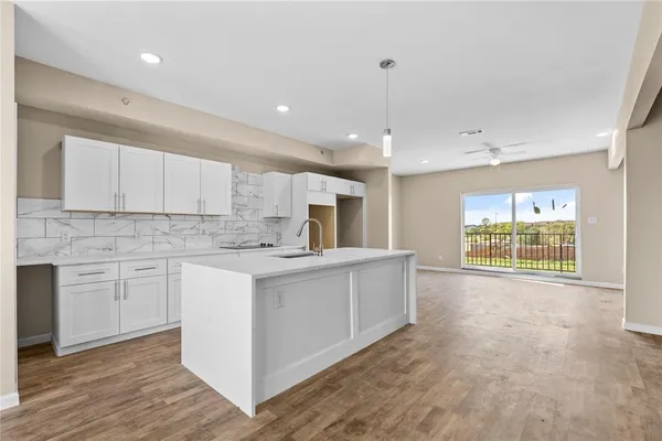 a kitchen with white cabinets and sink